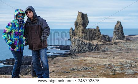 Asian Senior Couple Travel Photo With Iceland Pennisula Rock Landmark