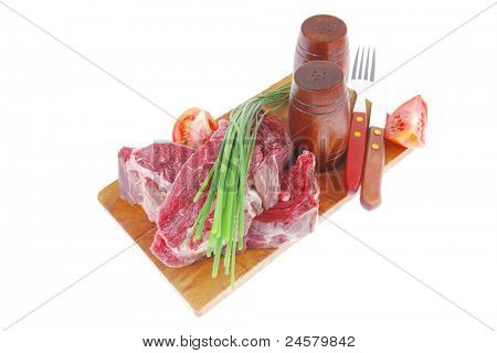 main course : fresh beef steak ready to prepare on cut board with cutlery and castor