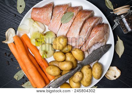Fish Raw Snapper With Herb Spices For Fish In Glass Jar, Pepper, Bay Leaf, Celery On Dark Wood Backg