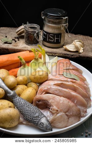 Fish Raw Snapper With Herb Spices For Fish In Glass Jar, Pepper, Bay Leaf, Celery On Dark Wood Backg