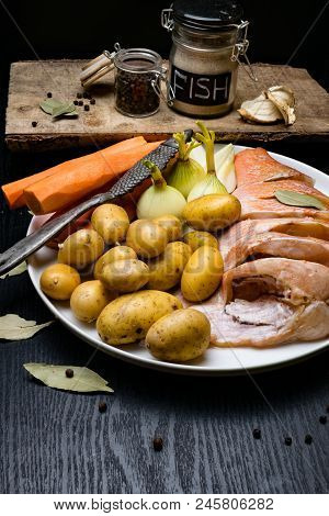 Fish Raw Snapper With Herb Spices For Fish In Glass Jar, Pepper, Bay Leaf, Celery On Dark Wood Backg