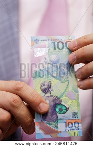ST. PETERSBURG, RUSSIA - MAY 23, 2018: General director of JSC Goznak Arkady Trachuk shows the commemorative banknote for FIFA World Cup 2018 in the exhibition 
