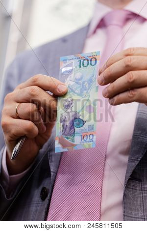 ST. PETERSBURG, RUSSIA - MAY 23, 2018: General director of JSC Goznak Arkady Trachuk shows the commemorative banknote for FIFA World Cup 2018 in the exhibition 
