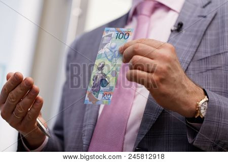 ST. PETERSBURG, RUSSIA - MAY 23, 2018: General director of JSC Goznak Arkady Trachuk shows the commemorative banknote for FIFA World Cup 2018 in the exhibition 