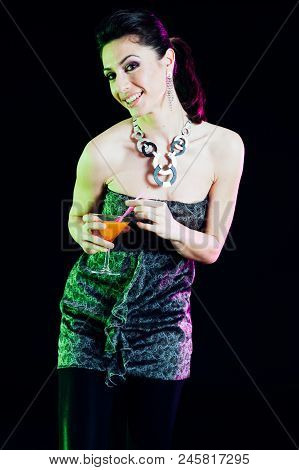 Young Caucasian Brunette Taking Aperitif With Black Background. Studio Shot