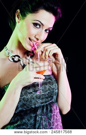 Young Caucasian Brunette Taking Aperitif With Black Background. Studio Shot