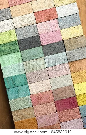 Abstract back ground, consisting of hand painted colored wooden cubes on grungy wooden background  warm earth colors or neutral colors. grey pale pink, green, beige.