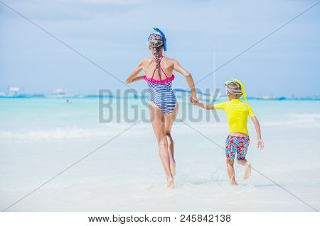 Back View Of Brother And Sister Runing And Having Fun On The Beach During The Hot Summer Vacation Da