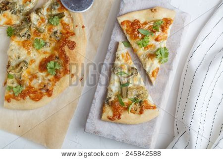Cheese Pizza With Artichoke And Arugula On Cutting Board, White Background, Top View