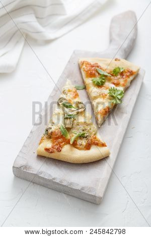 Two Pieces Of Cheese Pizza On White Cutting Board.
