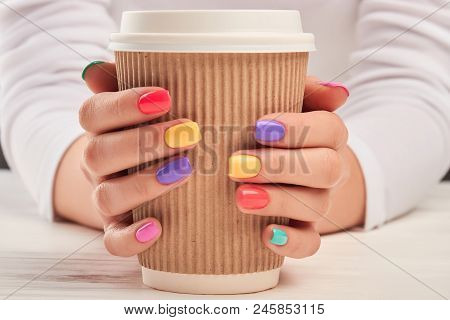 Large Cardboard Coffee Cup In Female Hands. Woman Hands With Colorful Summer Manicure Holding Big Di