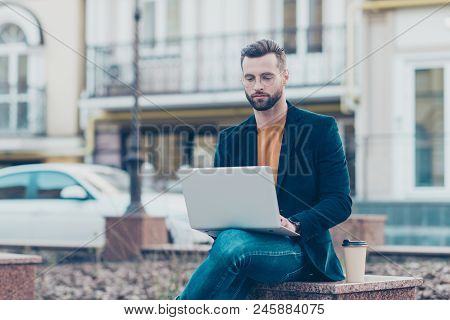 Portrait Of Busy Smart Man In Jeans Jacket Sitting Outdoor Using Laptop Chacking Email Chatting With