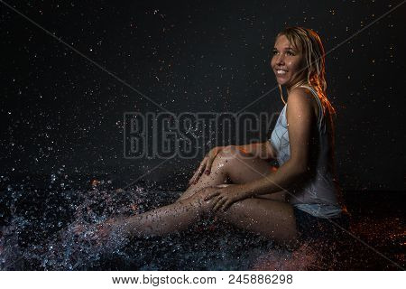 Nice Girl In The White Shirt And Water Drops Behind And Arround Her Illuminated By Light During A Ph