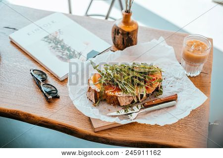 Kyiv, Ukraine - April 29, 2018: Breakfast At Cafe. Cup Of Cold Ice Latte, Toast With Prosciutto And 