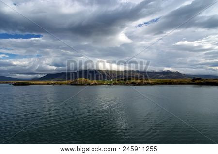 Sea Water At Mountain Coast Under Cloudy Sky In Rejkjavik, Iceland. Sea On Mountain Landscape. Beaut