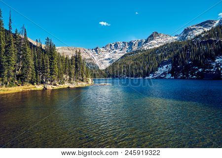 Lake Verna with rocks and mountains around at autumn. Rocky Mountain National Park in Colorado, USA. 