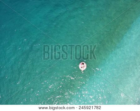 Aerial View Young Woman On Giant Inflated Flamingo Float In Turquois Water Of Ionian Sea Albania.