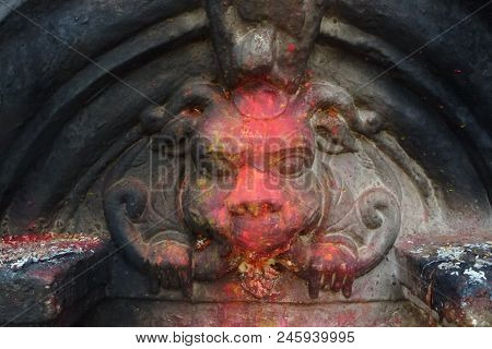 Statue Covered In Colored Powder At The Boudhanath Stupa, Kathmandu, Nepal