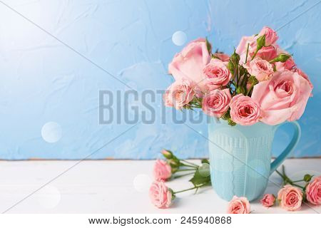 Background With Pnk Roses Flowers In Blue Cup In Ray Of Light  Against  Blue Textured Wall. Floral S