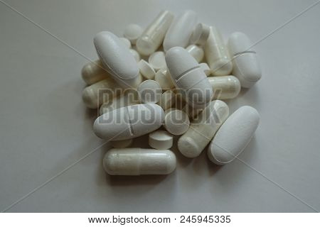 Handful Of White Magnesium Citrate Capsules, Calcium Citrate Caplets And Vitamin K2 Tablets