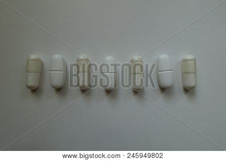 Cellulose Capsules Of Magnesium Citrate And Caplets Of Calcium Citrate In A Row From Above