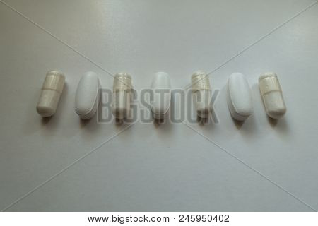 Oblong Tablets Of Calcium Citrate And Capsules Of Magnesium Citrate In A Row