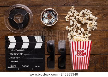 Cinema Background, Top View. Clapperboard, Popcorn, Soda And 3d Glasses On Wooden Table. Movie Goers