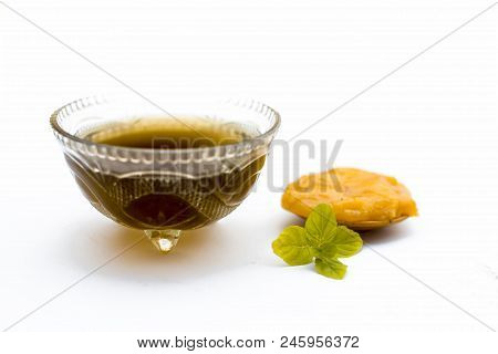 Jaggery Or Gud With Its Syrup In A Transparent Bowl Isolated On White.