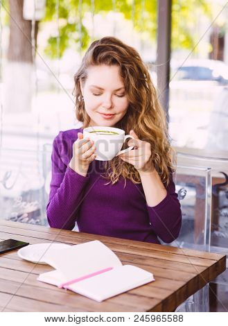 Beautifl Attractive Young Blonde Woman With Curly Hair Drinking Cappuccino In City Cafe Summer Day. 