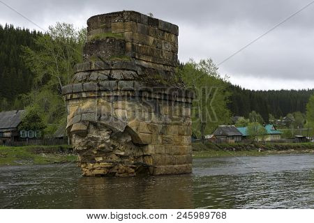 Support Of An Ancient River Bridge Destroyed By An Ice Break Across The River In The Village