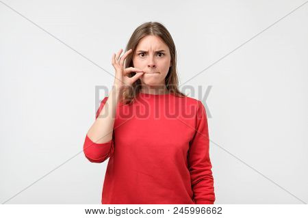 Beautiful European Woman In Red Pulover Showing Silence Sign On White Background