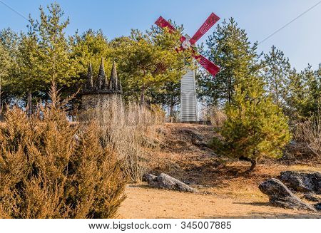 Gangwon-do, South Korea; January 12, 2020: Windmill Next To Miniature Rock Castle Surrounded By Ever