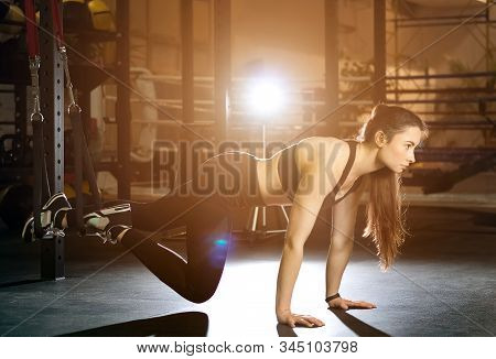 Young Athletic Woman Doing Suspension Training In Gym