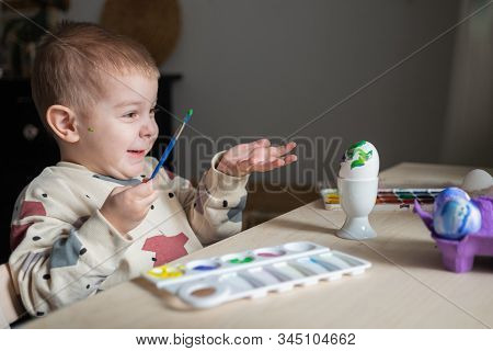 Toddler Boy Painting Easter Eggs Preparing For Holidays. Easter Tradition
