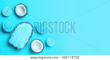 Creative Minimal Composition And Ripe Exotic Fruits Pineapple, Coconut, Lemon, Half Orange On A Blue
