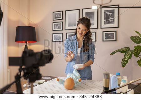 Female Vloger Recording Video About Cleaning Newborn Baby Ears With Safety Cotton Ear Buds As Part O