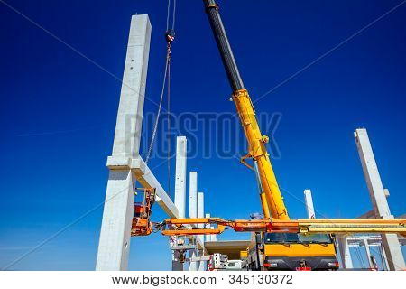 Mobile Crane Is Operating And Worker Is Assembly Concrete Joist In High Place. Height Worker Is Plac