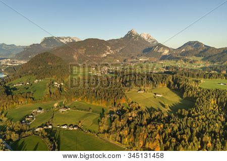 Aerial View Of Green Meadows With Villages And Forest In Austrian Alps Mountains.