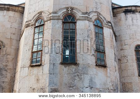 Narrow Vertical Blue Windows Of The Church, The Castle With A Wall Of Gray Old Brick.
