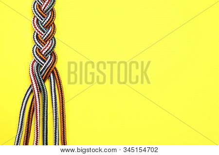 Top View Of Braided Colorful Ropes On Yellow Background, Space For Text. Unity Concept