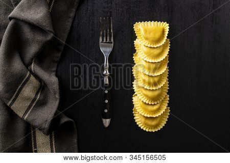 Italian stuffed pasta. Panzerotti pasta in bowl on old kitchen table. Flat lay.