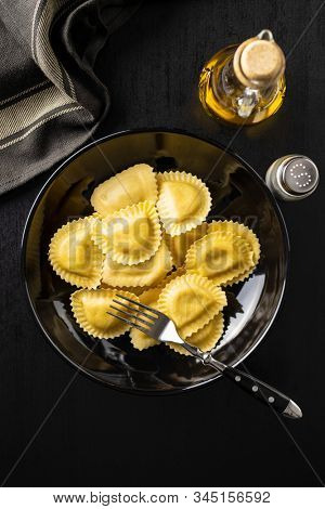 Italian stuffed pasta. Panzerotti pasta on plate on old kitchen table. Flat lay.