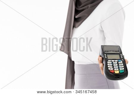 Close-up of confident happy smiling female muslim woman with EDC machine as owner merchant concept. Studio shot on white background. Using for sale consumerism and shopaholic concept.