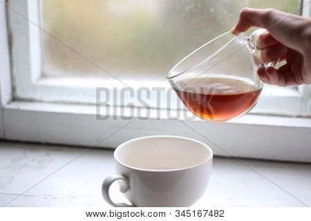 Someone Pours Tea From Mug To Mug
