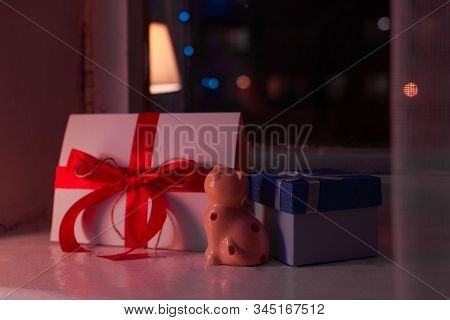 A Greeting Card, A Small Gift And A Statue Of A Cat Stand On The Window