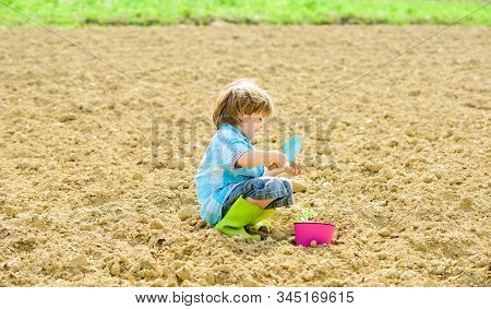 Small Kid Planting A Flower. Earth Day. New Life. Summer Farm. Happy Child Gardener. Botanic Worker.