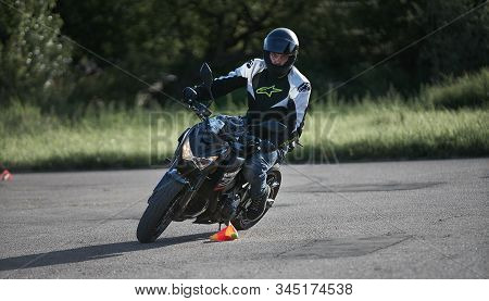 30-09-2019 Riga, Latvia. Motorcyclist On A Black Sports Motorcycle Rides On The Asphalt Ground