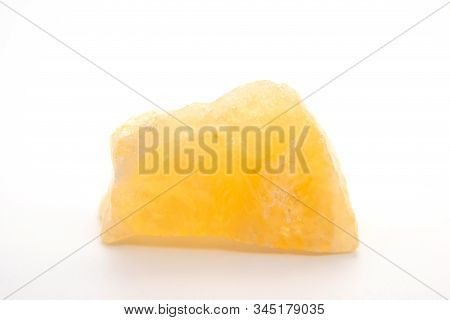 Macro Shooting Of Natural Mineral Rock Specimen - Raw Tea Calcite Stone On White Marble From Mexico