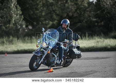 30-09-2019 Riga, Latvia. Motorcyclist On A Black Chopper Motorcycle Rides On The Asphalt Ground