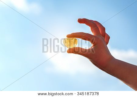 Heart Shaped Stone Held In Hands, Blue Sky In Background. Rockhounding Displays A Stone That Allows 